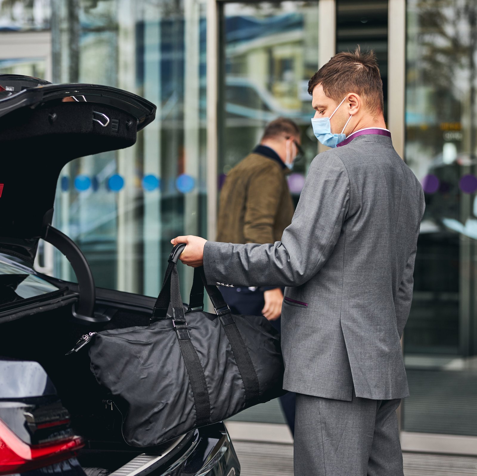 Driver helping his passenger with his luggage